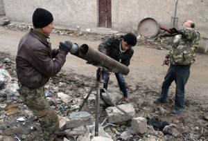 Opposition fighters prepare a homemade rocket-launcher during clashes with government forces near the airport on the outskirts of the northern Syrian city of Aleppo on January 27, 2104. Syrian peace talks in Geneva were deadlocked over the explosive issue of transferring power from President Bashar al-Assad's regime, delegates from the warring sides said. AFP PHOTO / AMC / ZEIN AL-RIFAI